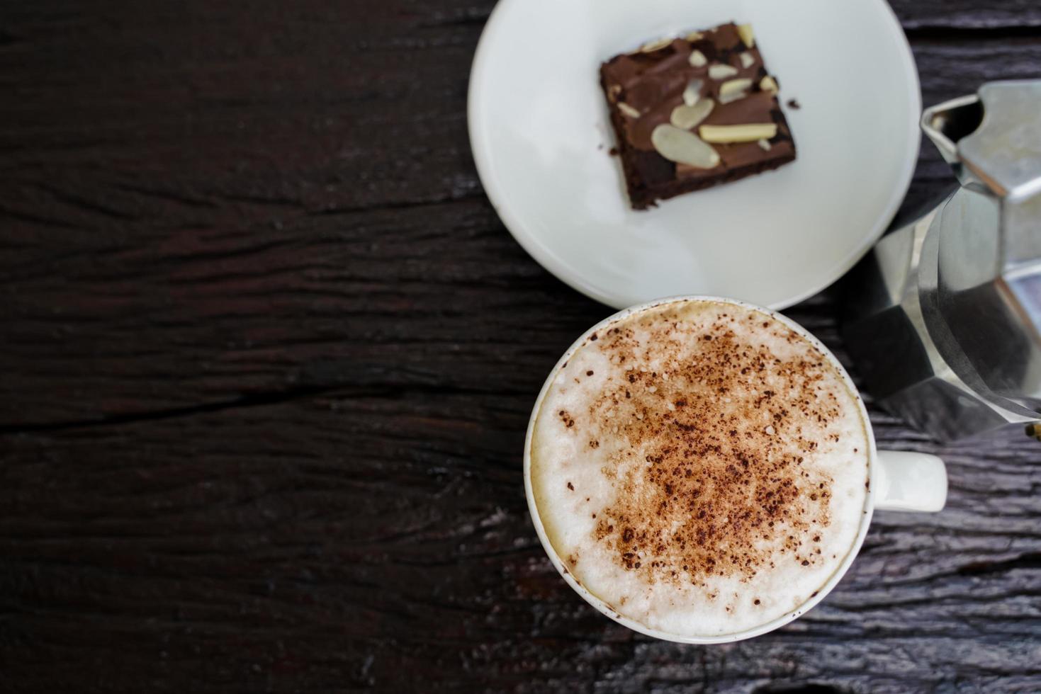 Hot cappuccino in white cup with wooden background,coffee is a popular drink all over the world. photo