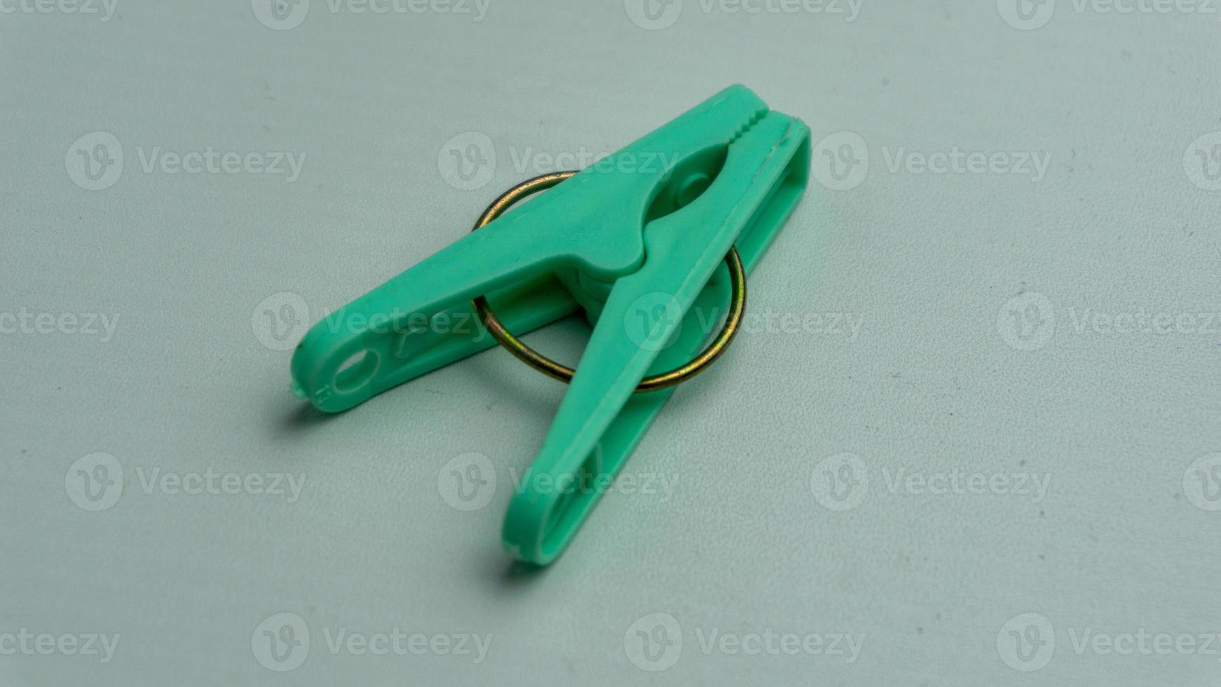 close up of green clothes peg or clothes pin isolated on white backround photo