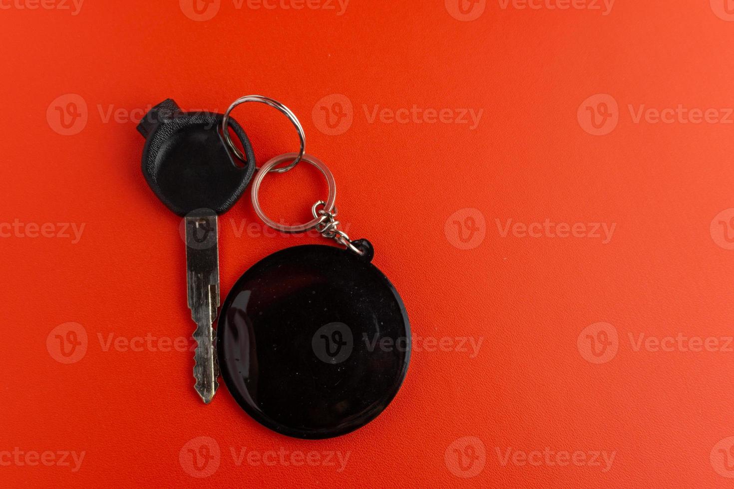 Black motorcycle key with black round keychain on red background. keychain mockup for design photo