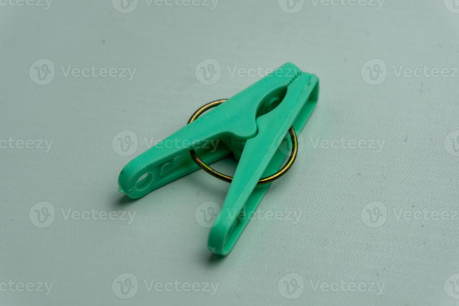 close up of green clothes peg or clothes pin isolated on white