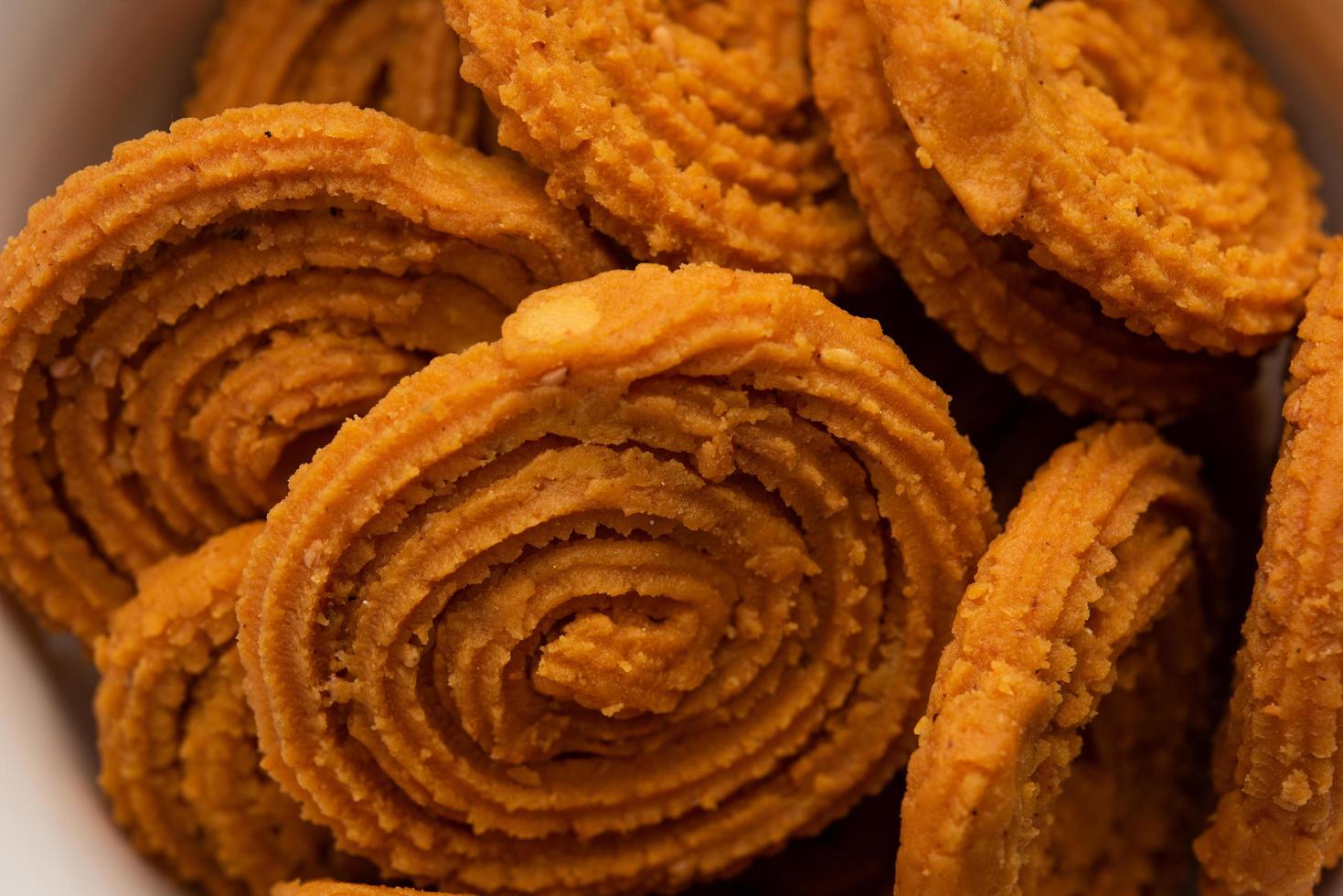 Chakli is a savoury snack from India. It is a spiral shaped snack with a spiked surface photo