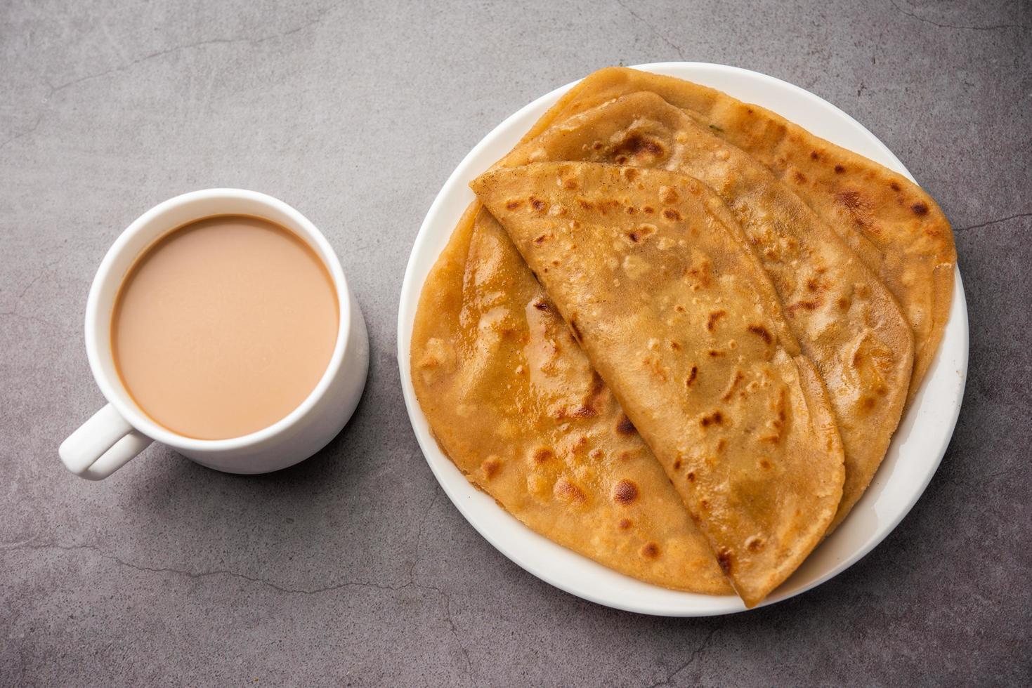 chai paratha: el té caliente servido con pan plano es una comida tradicional sencilla de india y pakistán foto