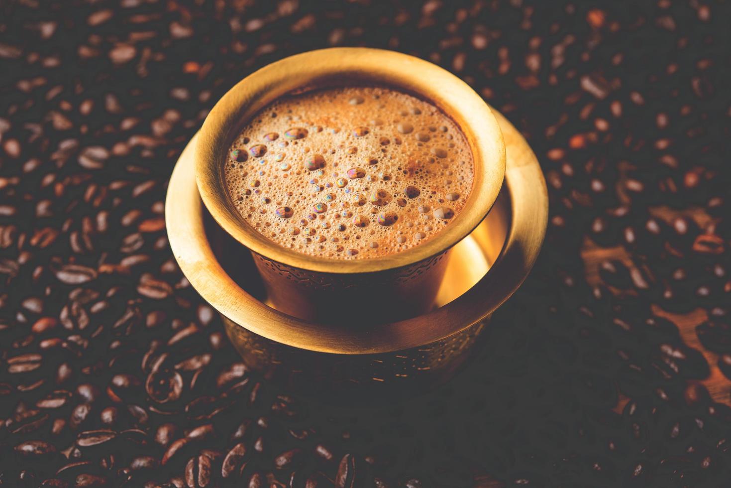 café de filtro del sur de la India servido en una taza tradicional de latón o acero inoxidable foto