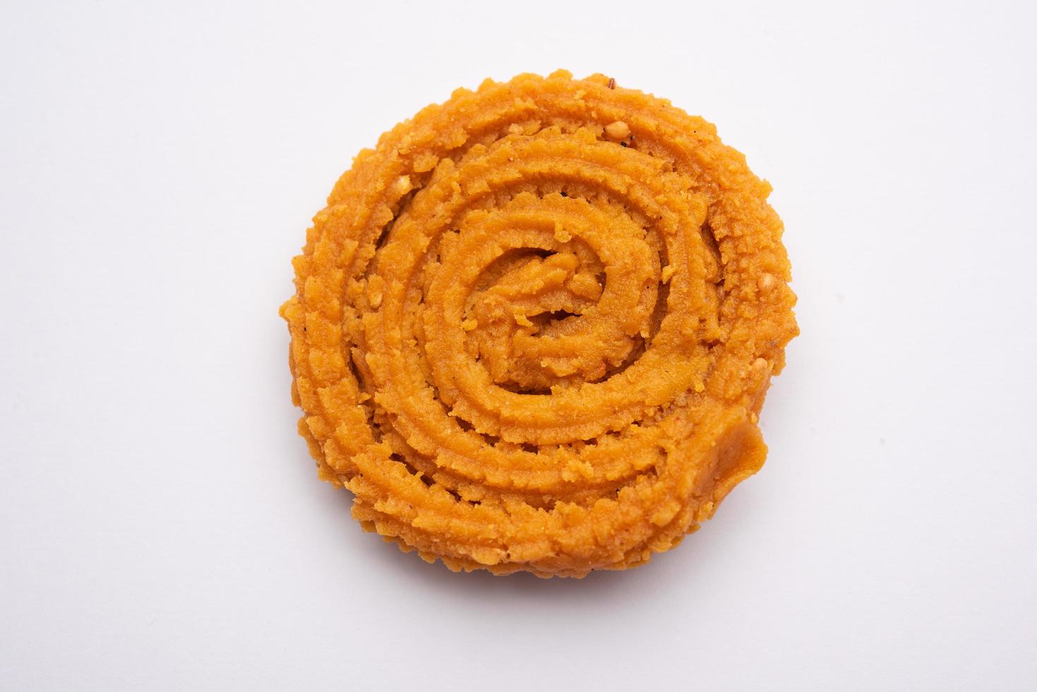 Chakli is a savoury snack from India. It is a spiral shaped snack with a spiked surface photo