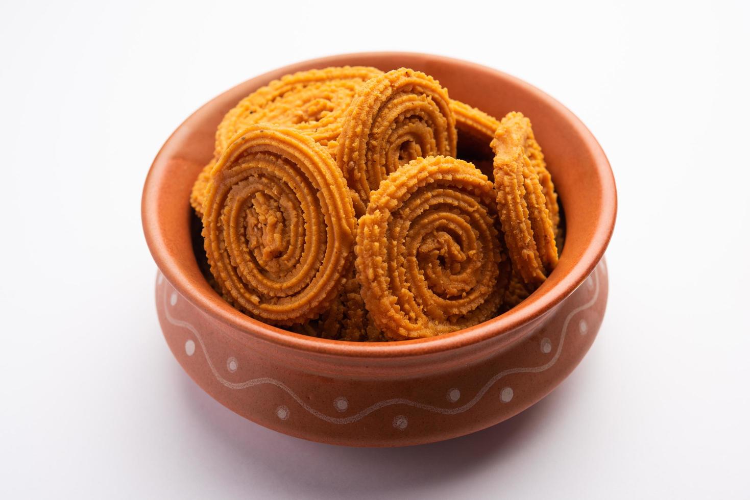 Chakli is a savoury snack from India. It is a spiral shaped snack with a spiked surface photo
