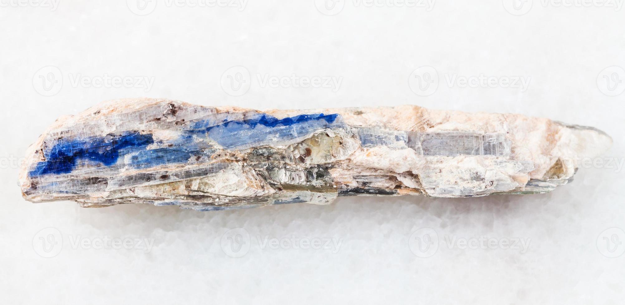 rough blue kyanite stone on white marble photo