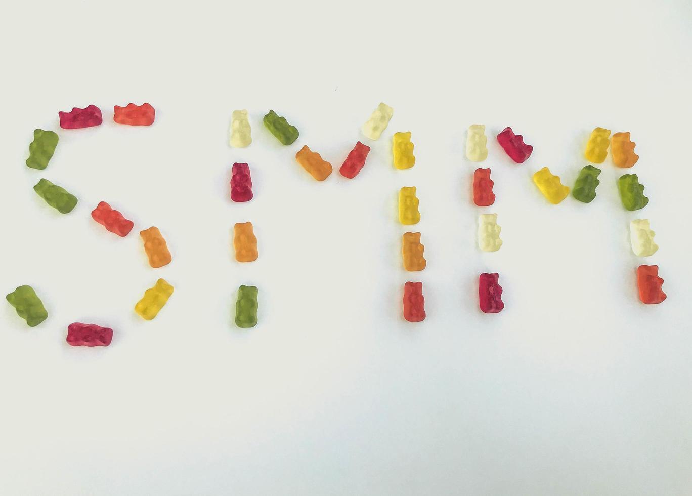 letter from multi-colored gummy bears. Letter S and M made from gelatinous candies. edible word SMM. marketing of gummies. bright sweet gummy bears photo