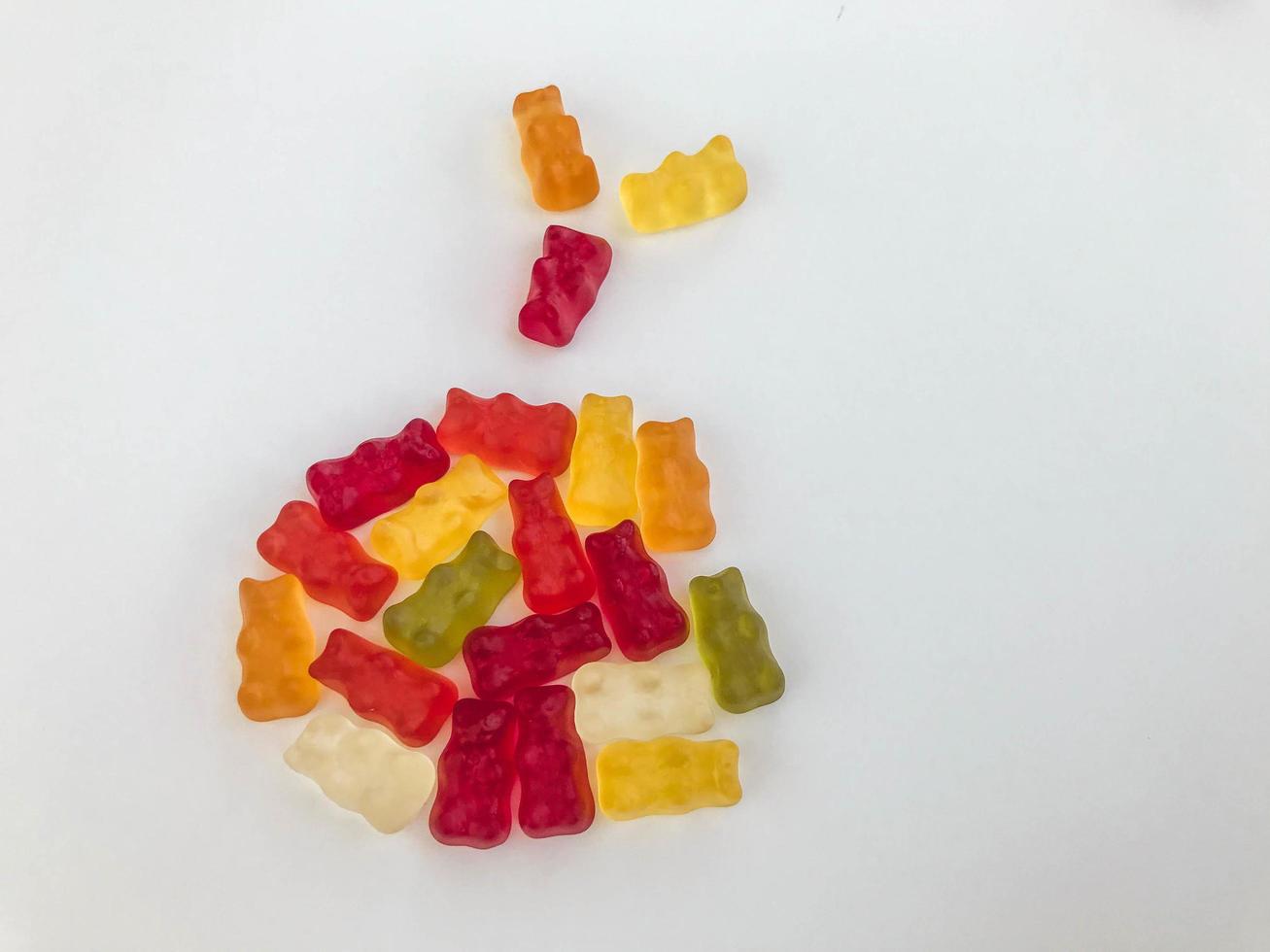 sweet dessert. gummy bears in the shape of a Christmas ball. bright, colored, voluminous gummies. unusual shape on a white matte background. delicious and high-calorie dessert photo