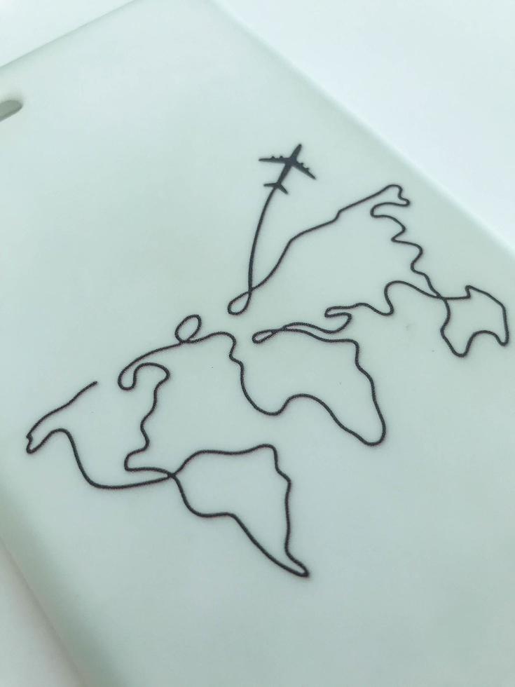 white matte phone case with world map. the plane flies to another continent. black thick lines on the material. rubber texture, smooth homogeneous structure photo