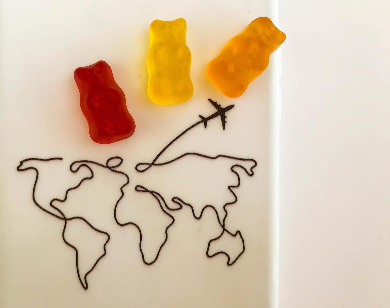gummy bears are going to travel the world. bears fly on vacation by plane, enjoy the sun and warm countries. unusual travel with food. games with food. candy sweets photo