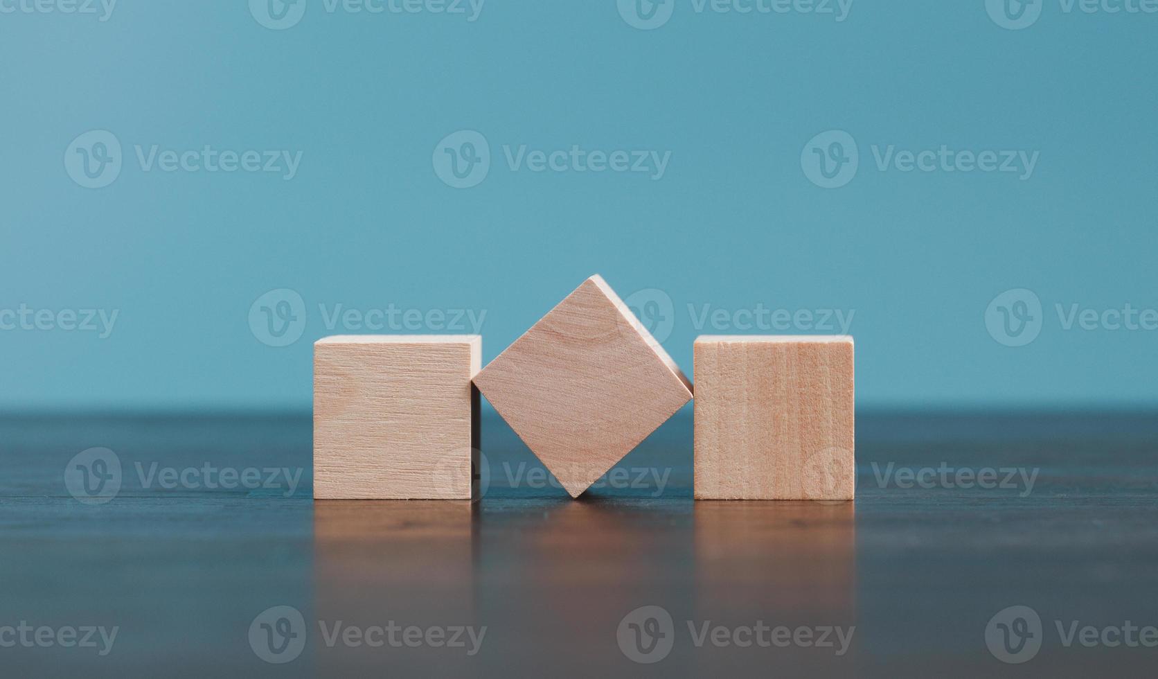 Stacking blank wooden cubes on blue background with copy space for input wording and infographic icon. Empty brown wooden object block for symbol icon put technology, zero gravity, business concept. photo