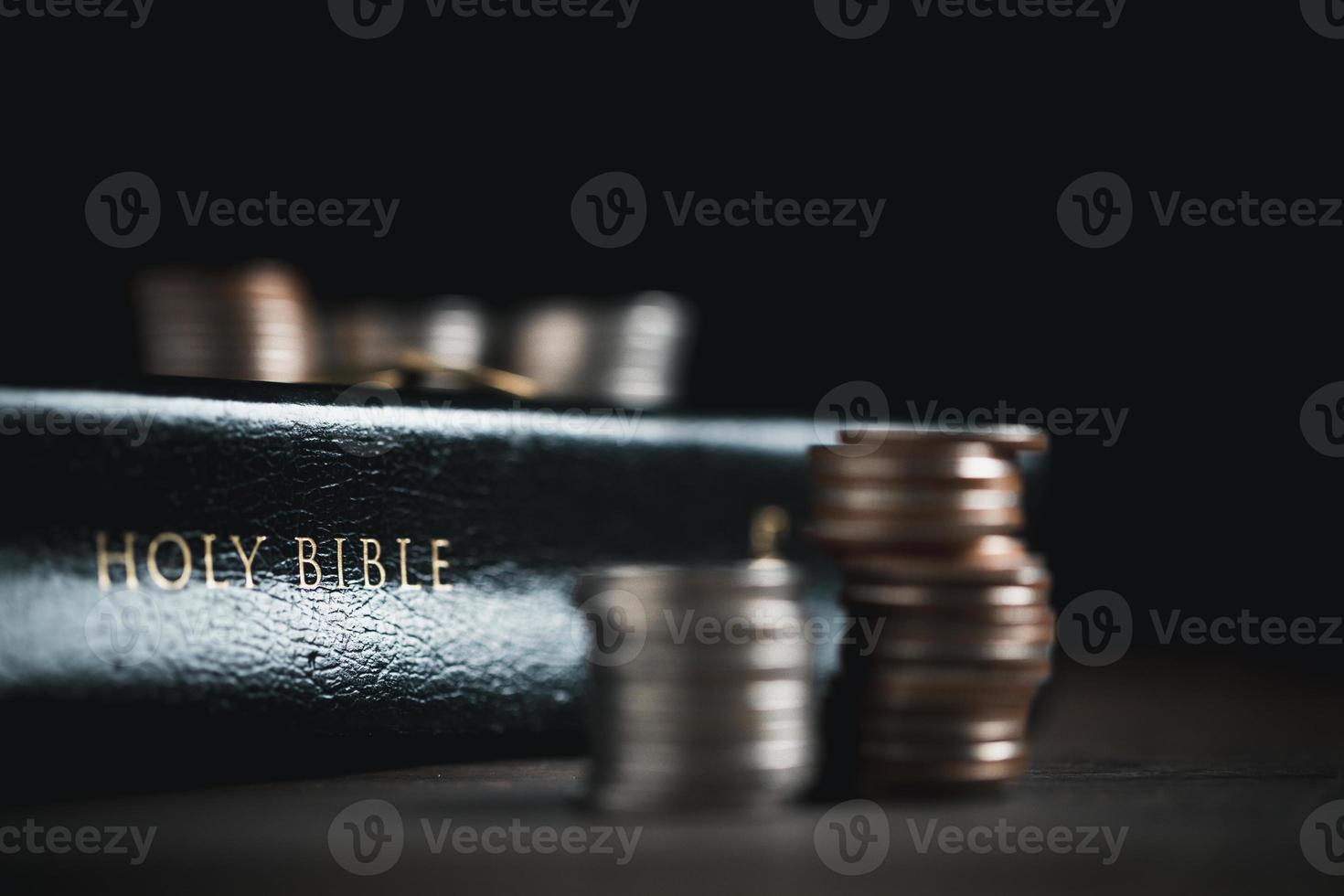 One tenth or tithe is basis on which Bible teaches us to give one tenth of first fruit to God. coins with Holy Bible. Biblical concept of Christian offering, generosity, and giving tithes in church. photo
