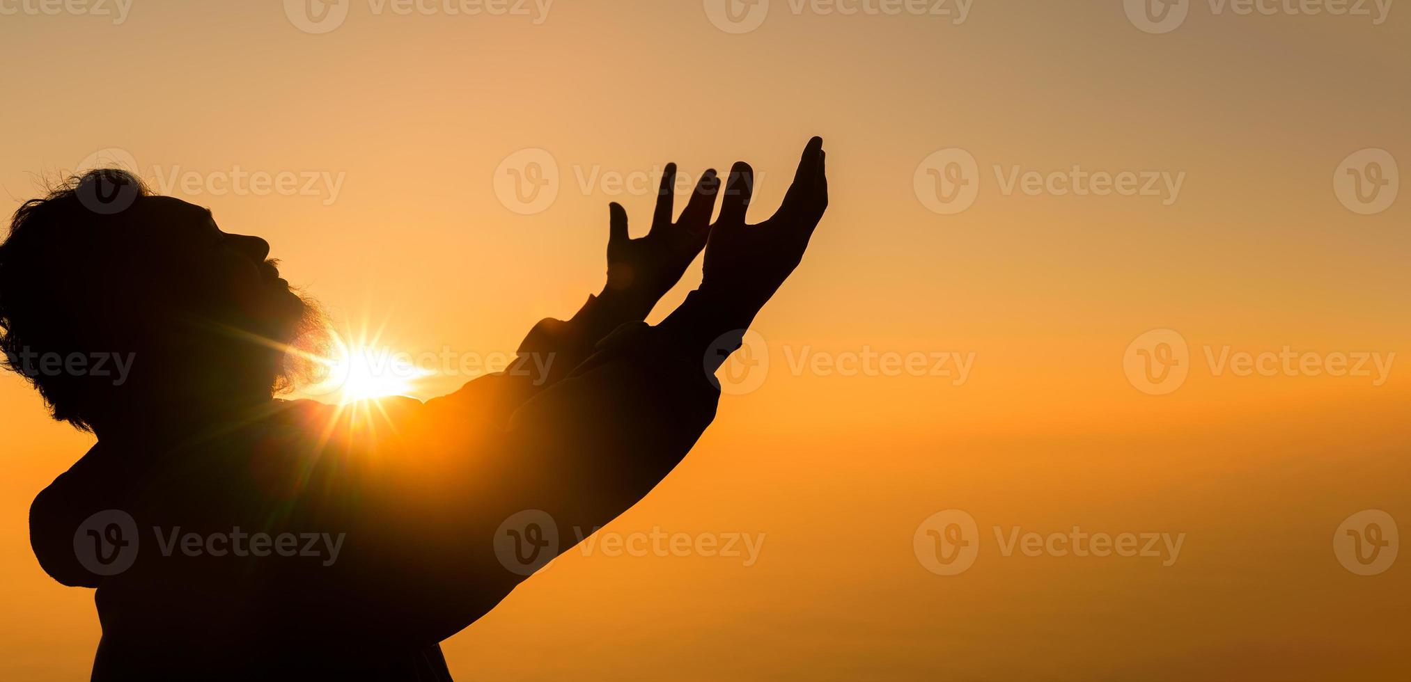 concepto persona cristiana adorar o rezar a dios. silueta de hombre cristiano con amor, fe, devoción a dios con fondo de cielo de amanecer. los hombres adoran a dios por la paz, la victoria, el éxito con esperanza. religión foto