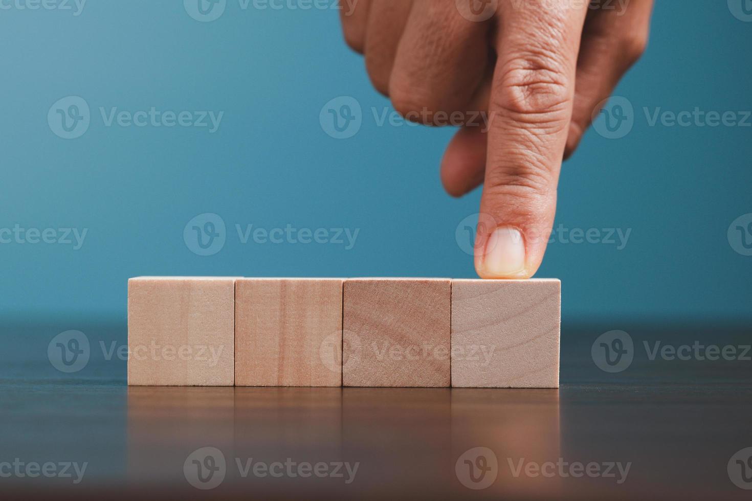 Stacking blank wooden cubes on blue background with copy space for input wording and infographic icon. Empty brown wooden object block for symbol icon put technology, zero gravity, business concept. photo