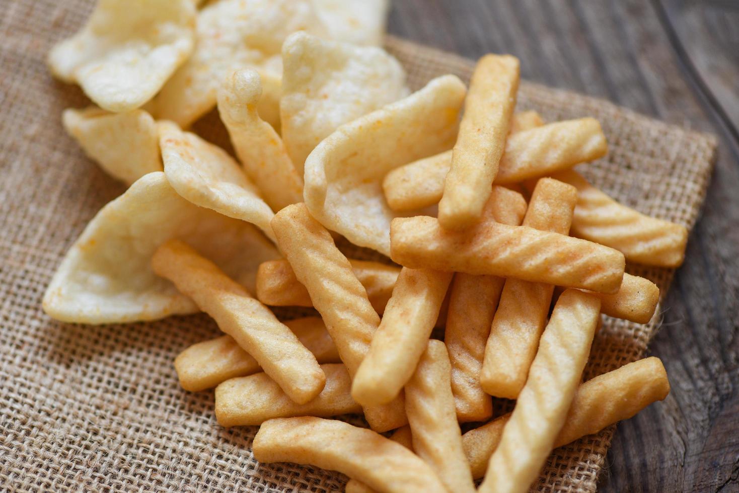 crunchy prawn crackers or shrimp crisp rice and ketchup for traditional snack - prawn crackers stick on sack and wooden table background photo