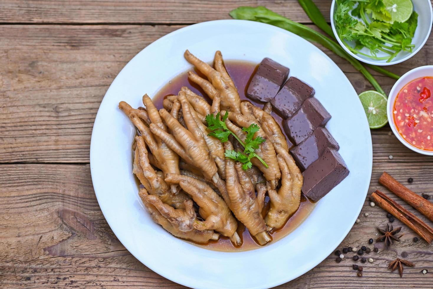 Thai food, chicken feet soup stewed, cooking chicken feet foot stew on white with herbs and spices ingredients with chilli lemon vegetable on wooden background, Asian chinese food menu stew photo