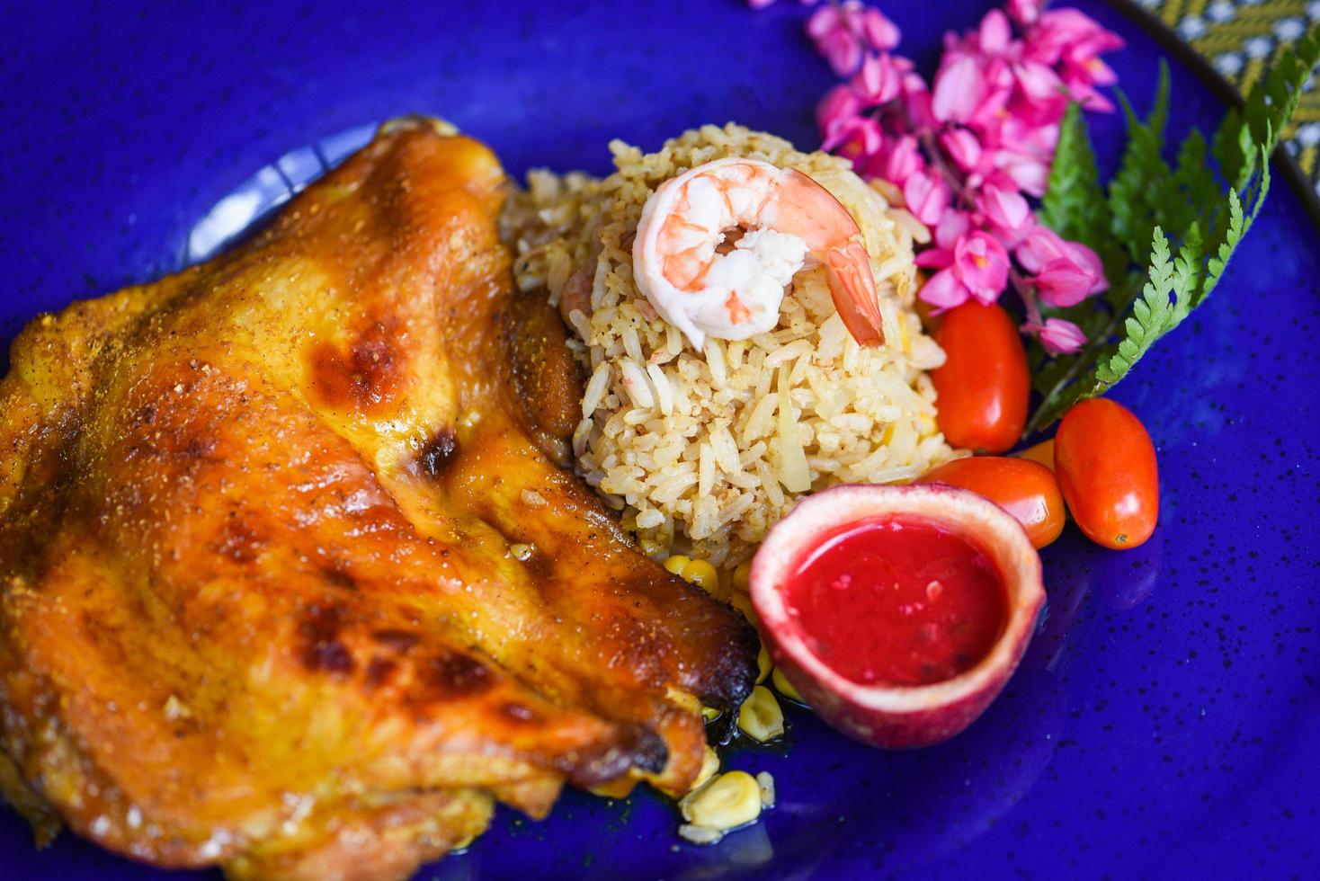 pollo asado - tabaka de pollo a la parrilla con salsa roja y camarones de arroz frito en un plato de comida asiática en tailandés foto