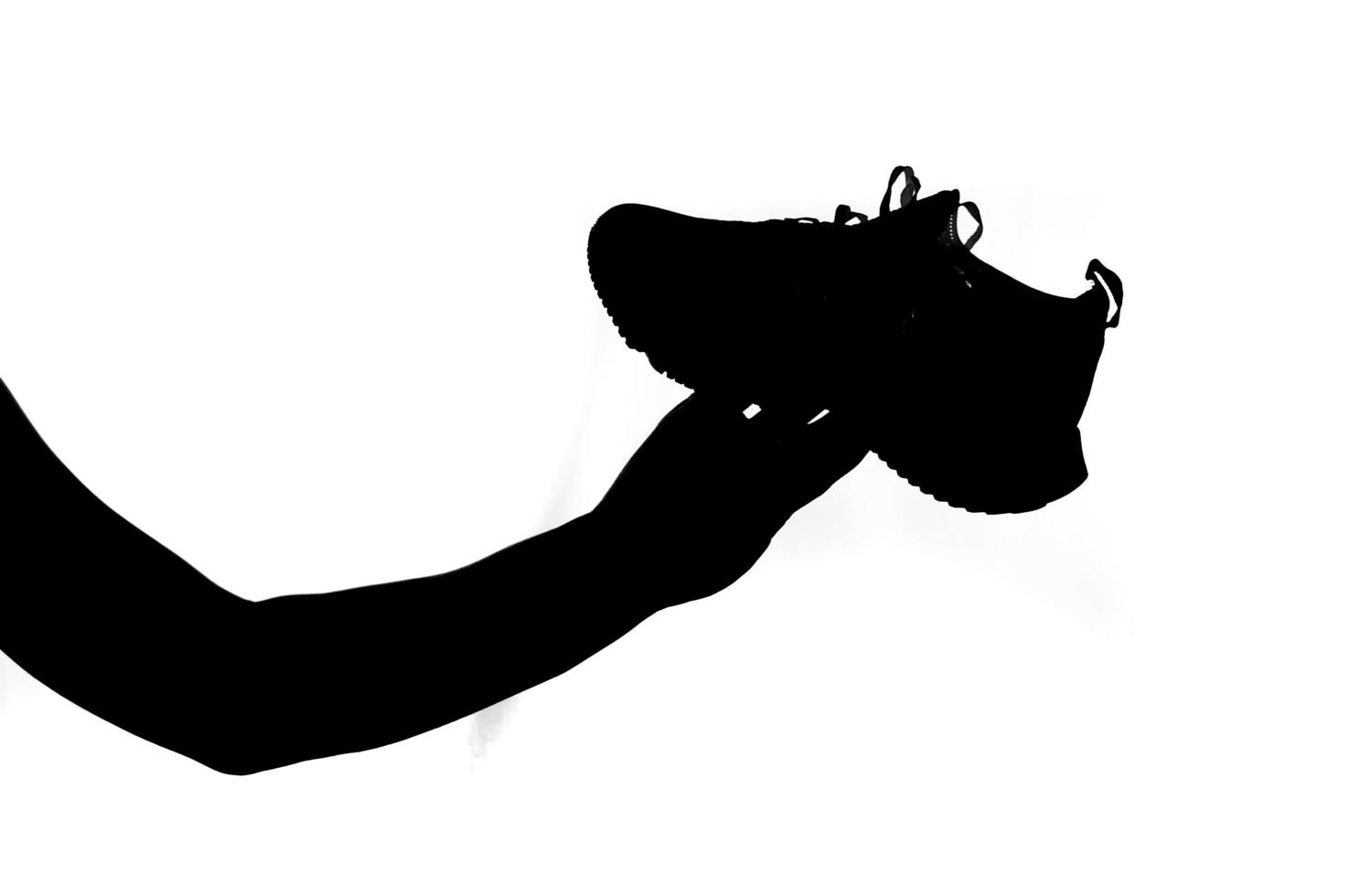 man's hand holding a running shoe on a white background. Ideas for buying running shoes and exercise. photo