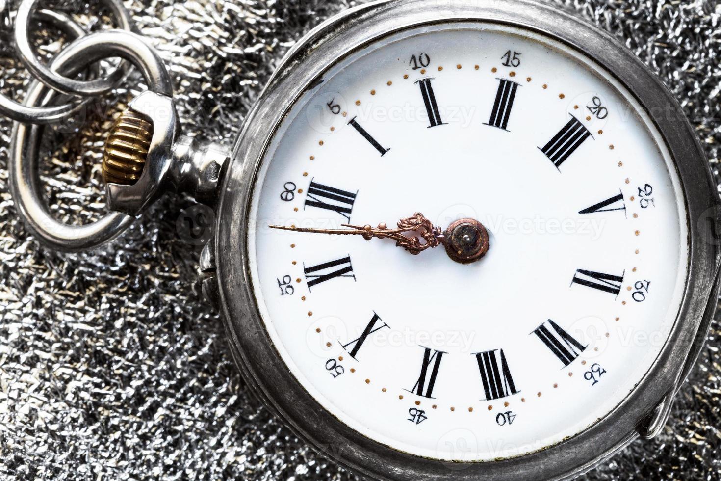 vintage pocket watch on silver cloth close up photo