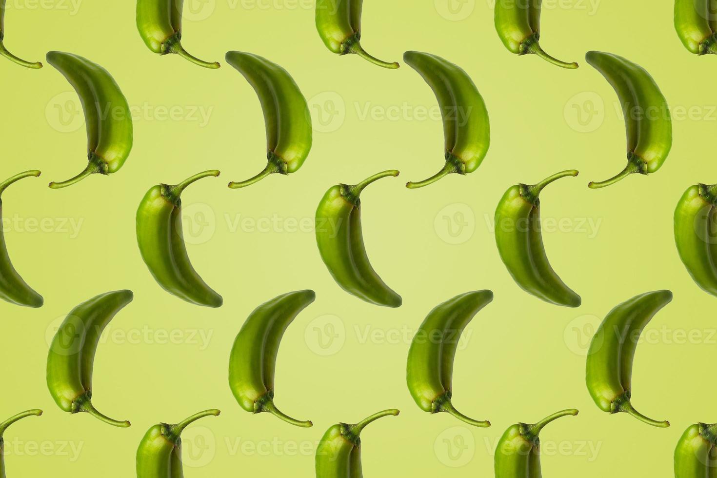 Pattern of green peppers isolated on light green background. Creative photo of peppers aligned with copy space.