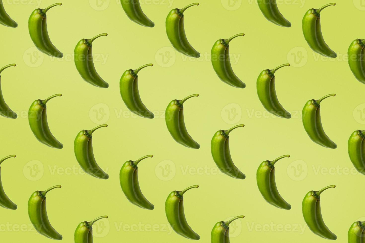 Pattern of green peppers isolated on light green background. Creative photo of peppers aligned with copy space.