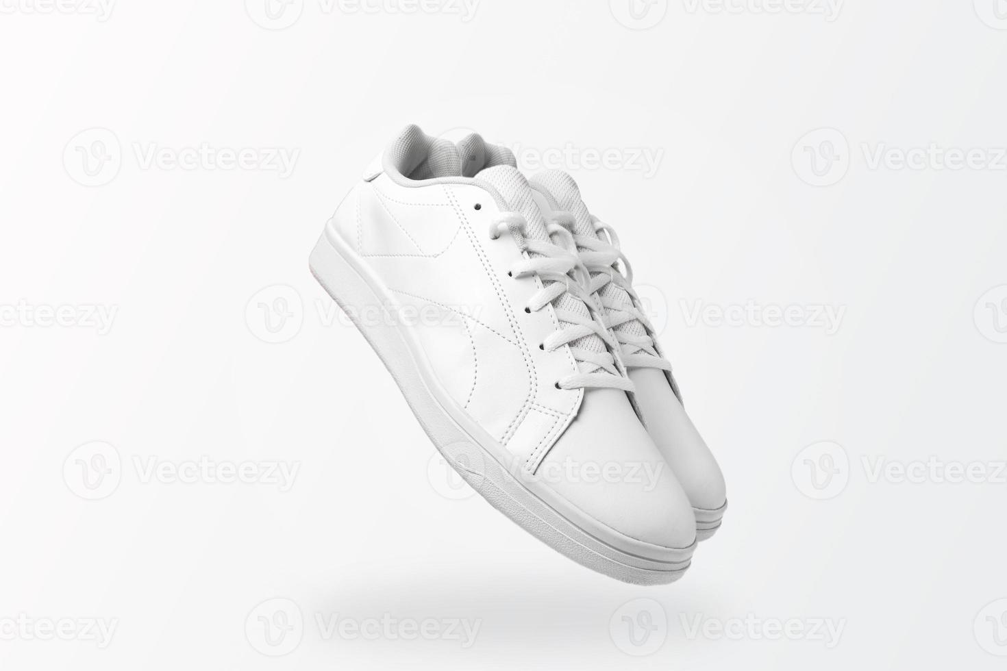 New pair of white sneakers isolated on white background for cutting out. Sportive pair of shoes for mockup. Fashionable stylish sports casual shoes. photo