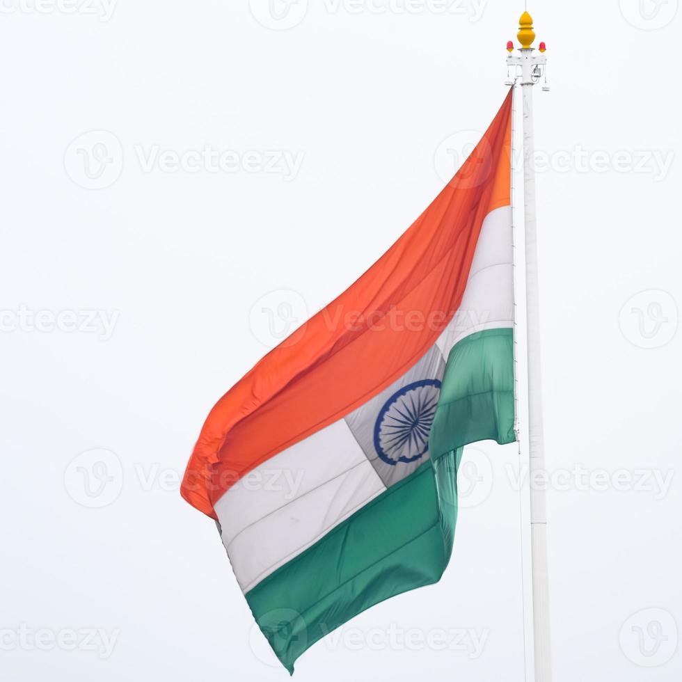 India flag flying high at Connaught Place with pride in blue sky, India flag fluttering, Indian Flag on Independence Day and Republic Day of India, tilt up shot, Waving Indian flag, Har Ghar Tiranga photo