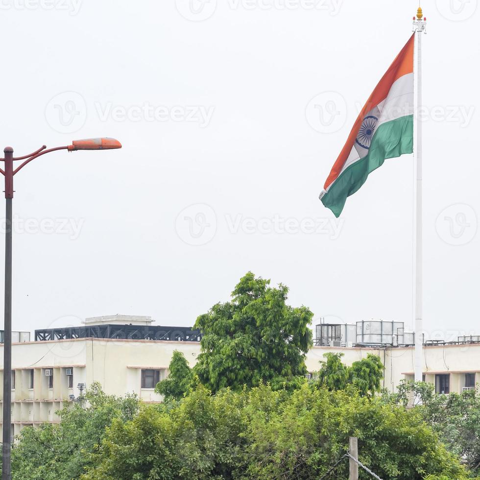 India flag flying high at Connaught Place with pride in blue sky, India flag fluttering, Indian Flag on Independence Day and Republic Day of India, tilt up shot, Waving Indian flag, Har Ghar Tiranga photo