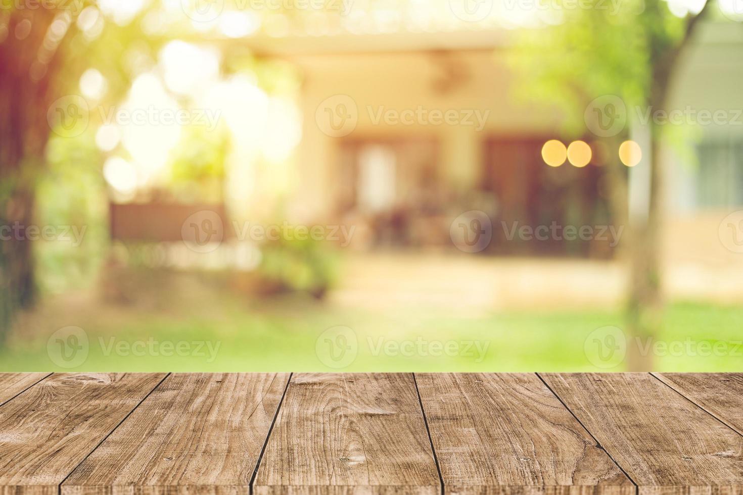 espacio de mesa de madera con fondo de desenfoque de vista de patio trasero de casa verde para plantilla de publicidad foto