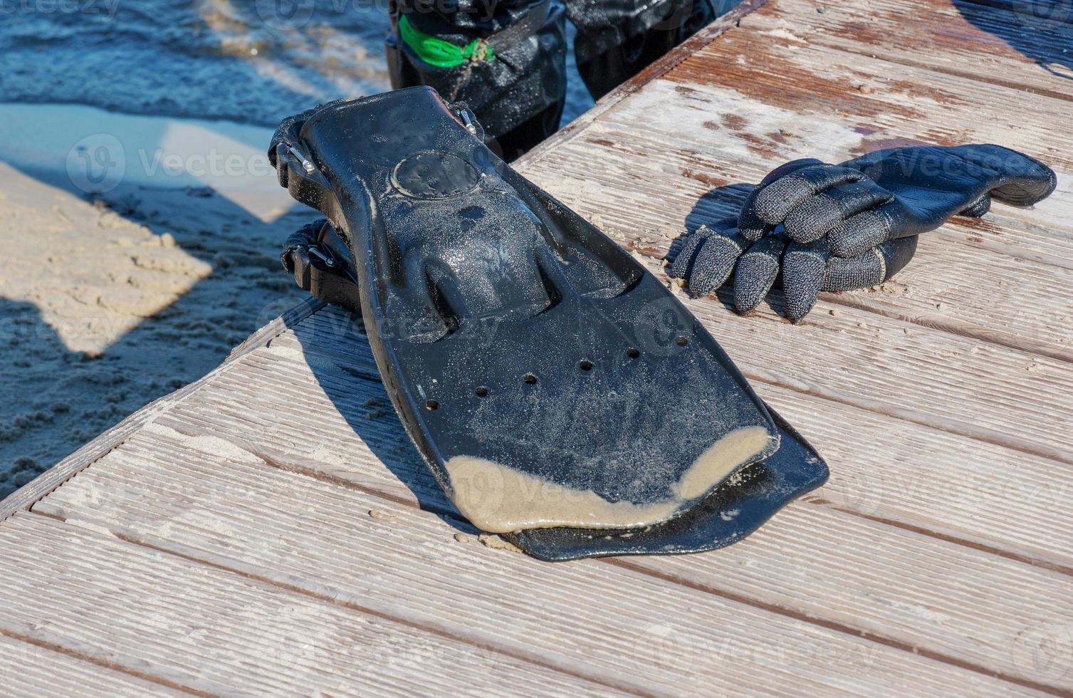 A professional diver near the coastline of the river. Diver's fins and gloves. Commercial diving. photo