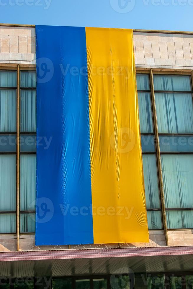 The national flag of Ukraine flutters in the wind. The national symbol of the Ukrainian people on the building. photo