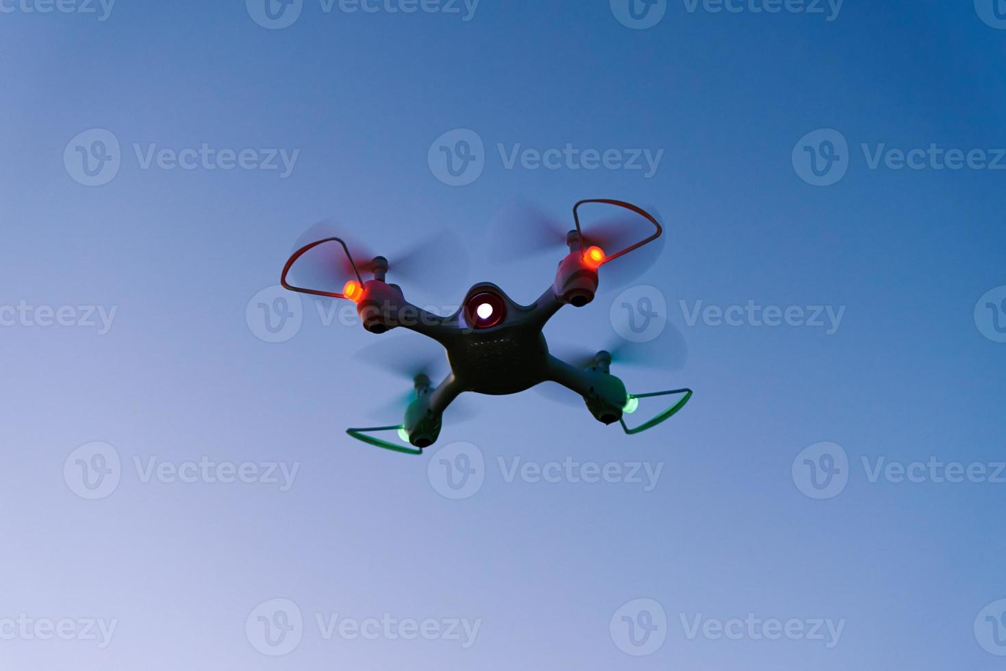 Toy drone quad copter against sunset sky photo