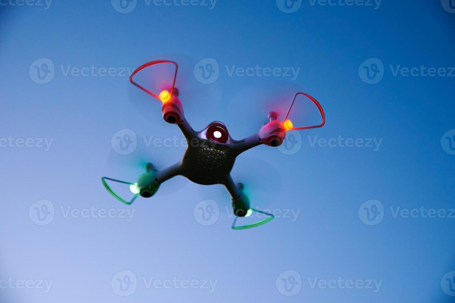 Toy drone quad copter against sunset sky photo