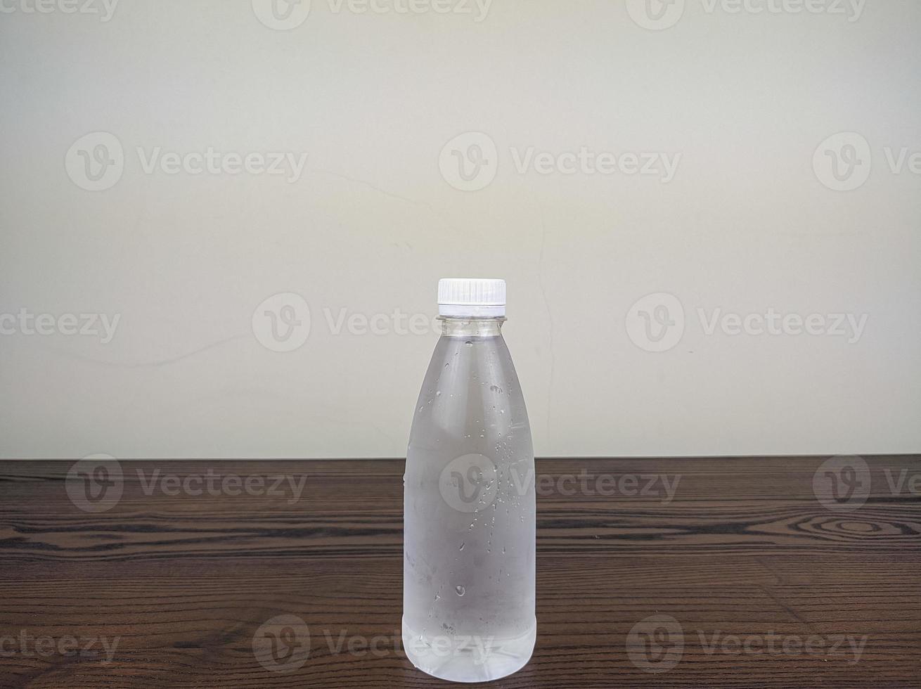 close up cold plastic drink bottle on wooden table photo