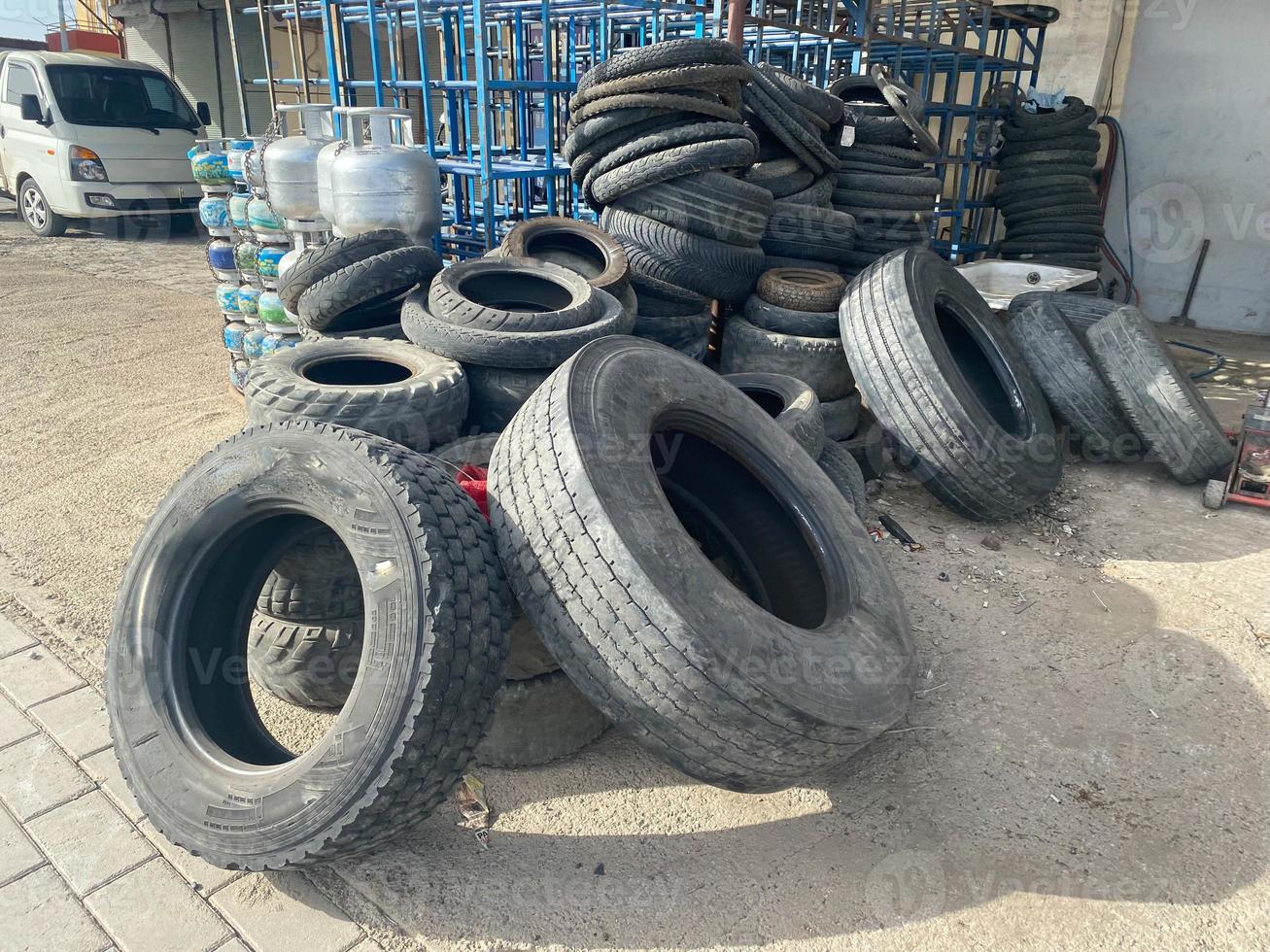 A large pile of lying black rubber wheels, tires for cars in an industrial warehouse photo