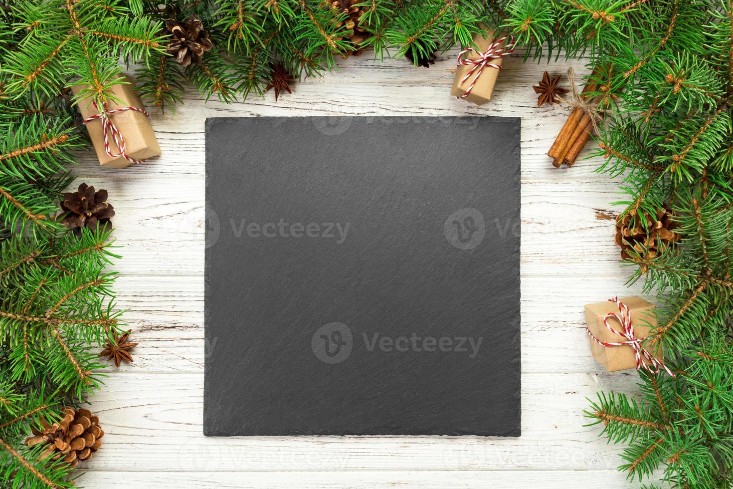 top view. Empty black slate square plate on wooden christmas background. holiday dinner dish concept with new year decor photo