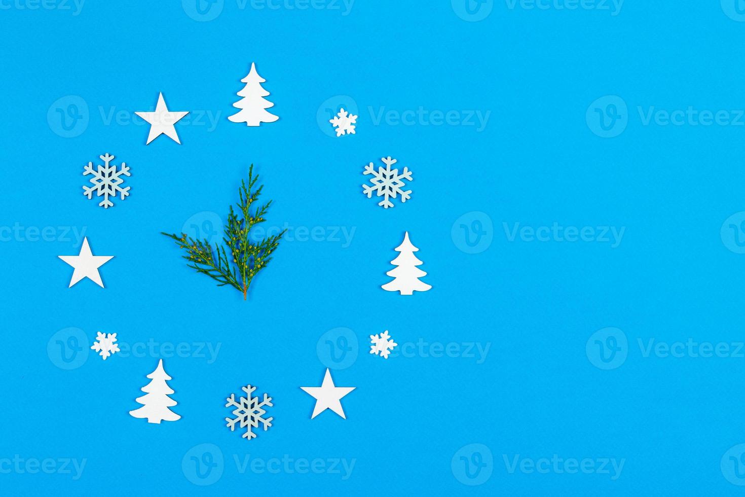 Concept clock made of christmas decoration showing five to midnight New Year on blue background with copy space photo