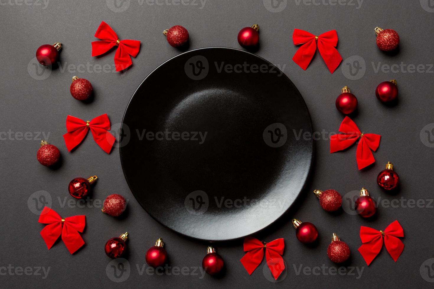 Top view of holiday dinner on colorful background. Plate, baubles and bows. Christmas Eve concept photo
