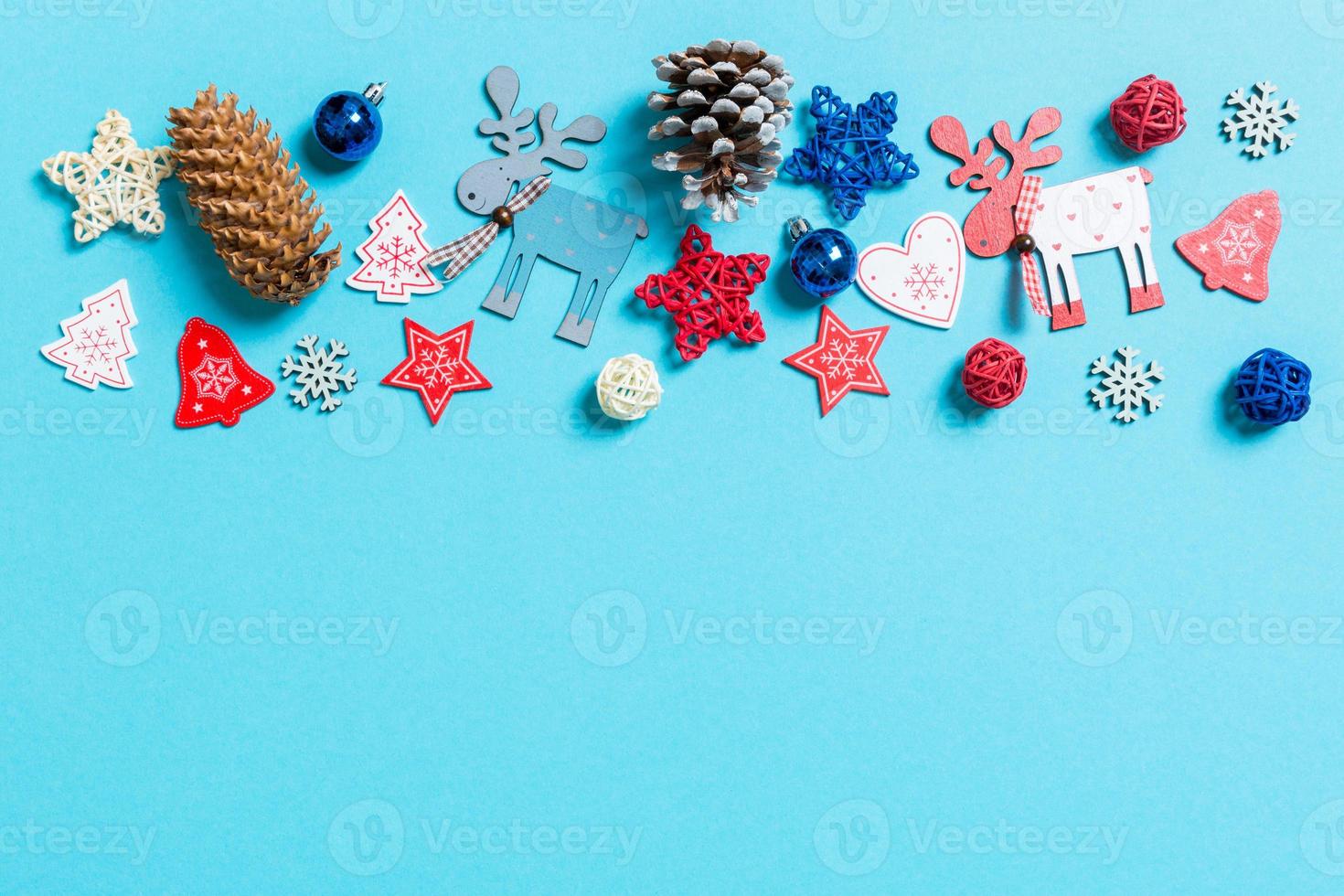 Top view of New Year toys and decorations on blue background. Christmas time concept with empty space for your design photo