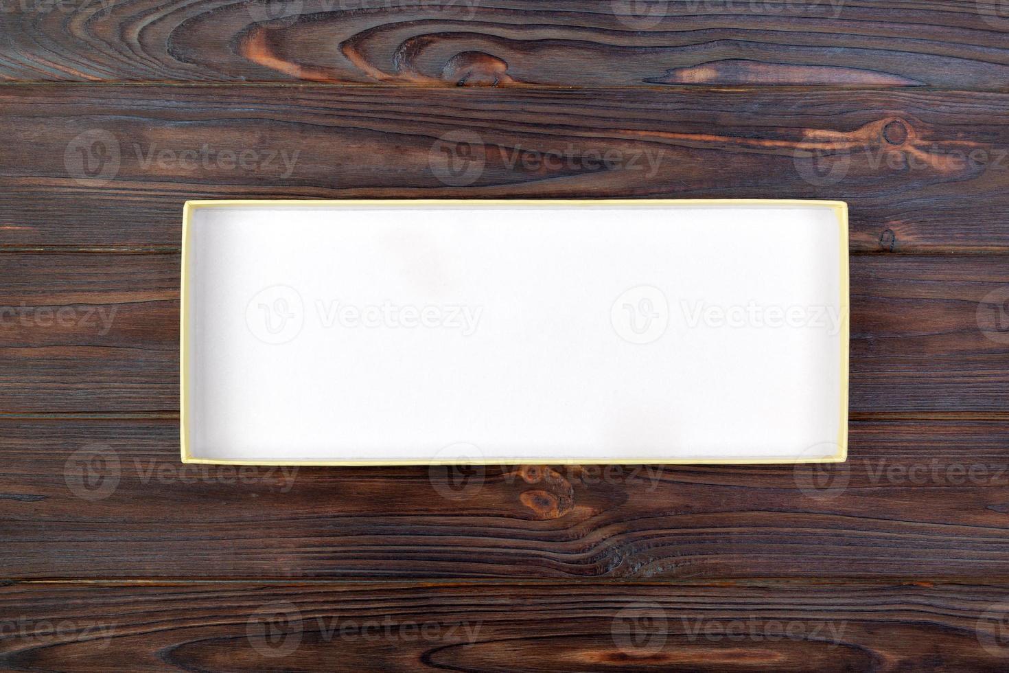 Open Cardboard white box on a dark table, wooden background. top view photo