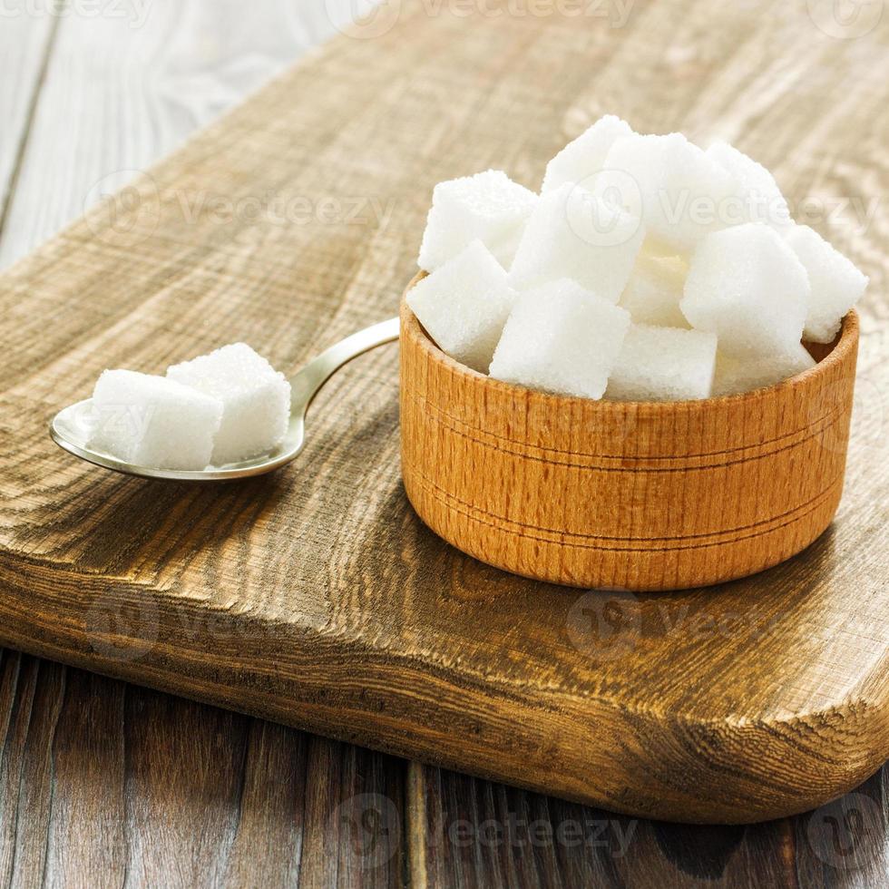 Sugar background. Sugar cubes, granulated sugar in spoon and plate. White sugar on gray galvanized iron background. Copy space photo