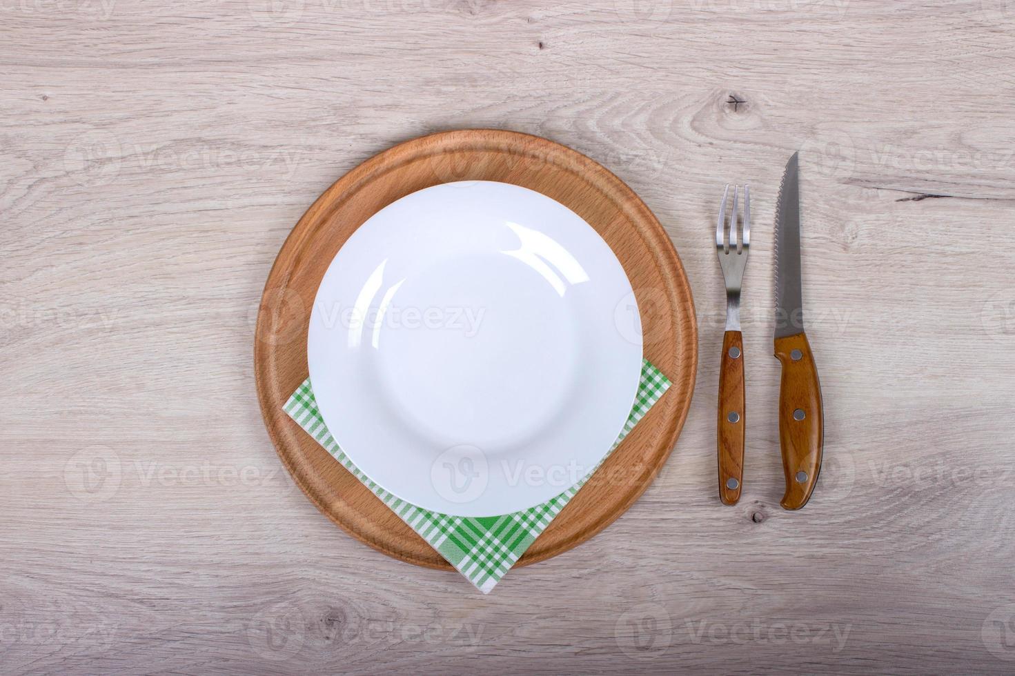 Empty Plate, Fork and Knife on wooden background. photo