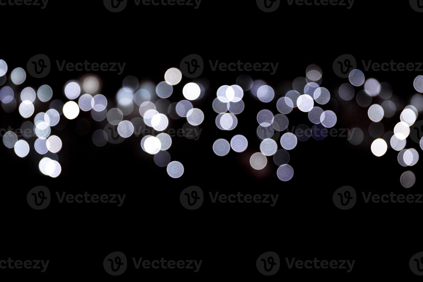 Abstract bokeh of white city lights on black background. defocused and blurred many round light photo