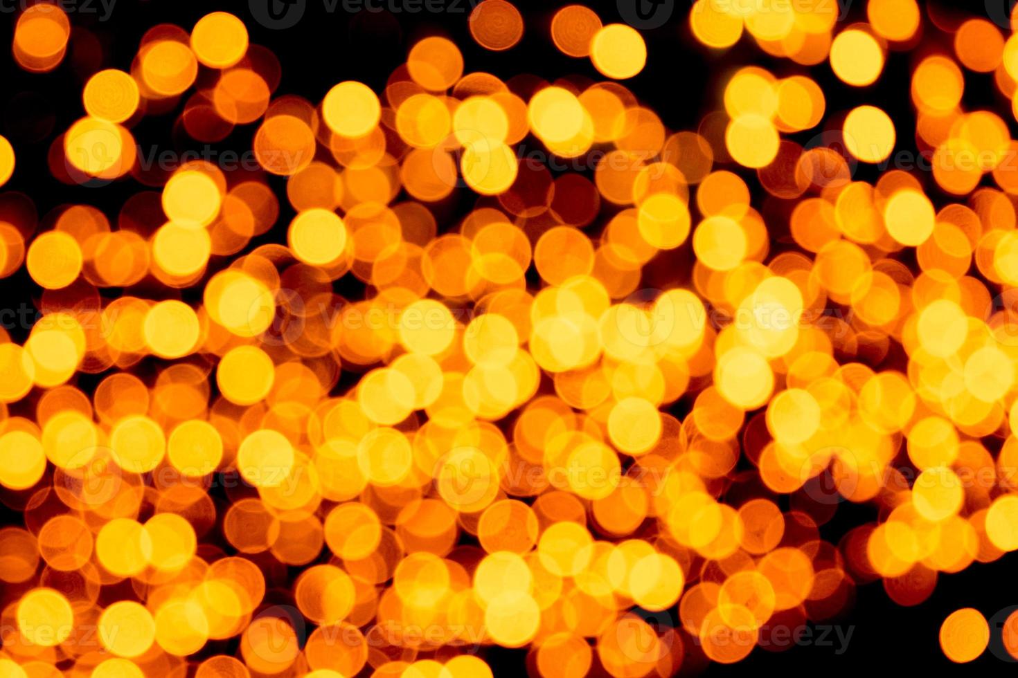 Unfocused abstract yellow bokeh on black background. defocused and blurred many round light photo