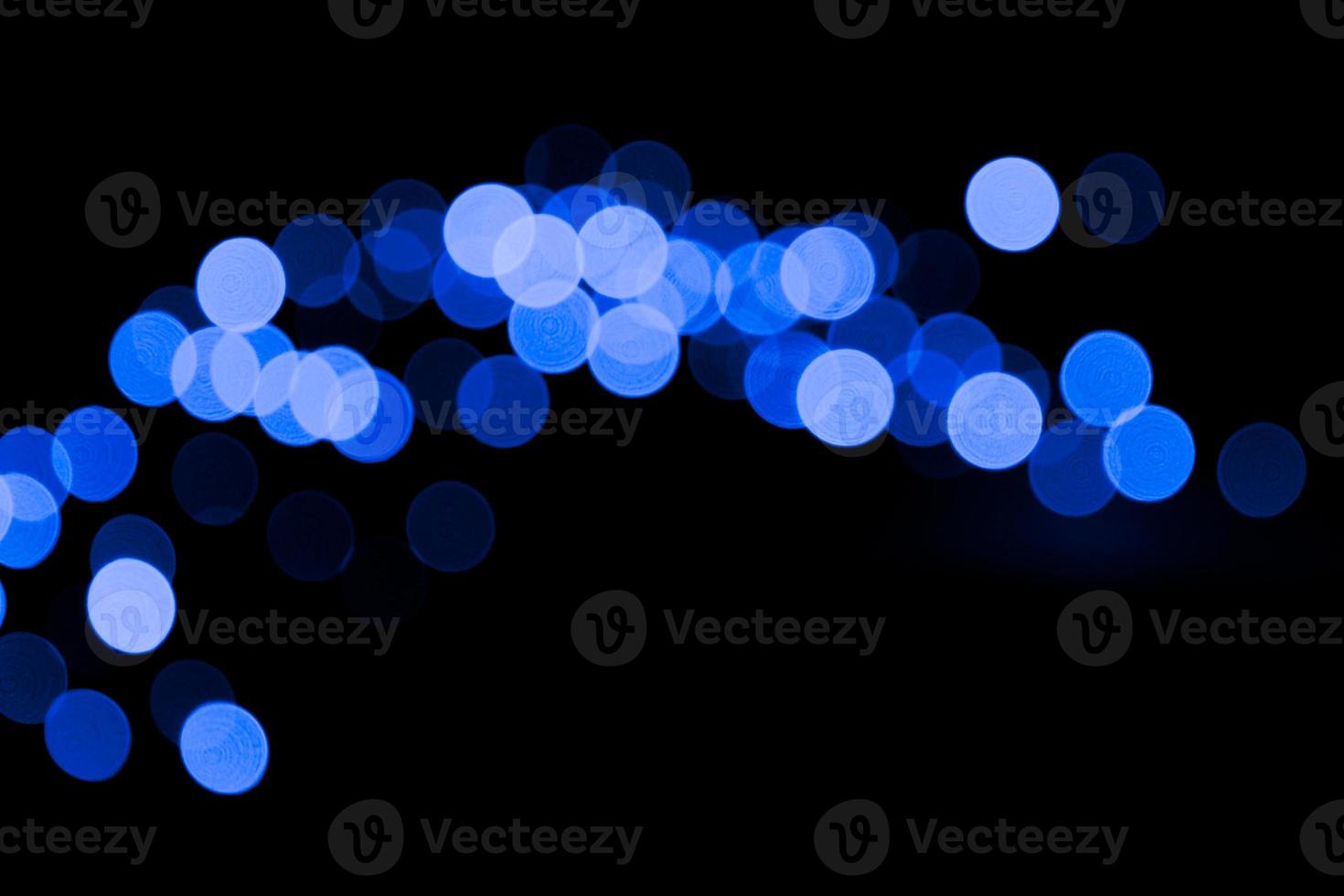 Unfocused abstract colourful bokeh black background. defocused and blurred many round blue light photo