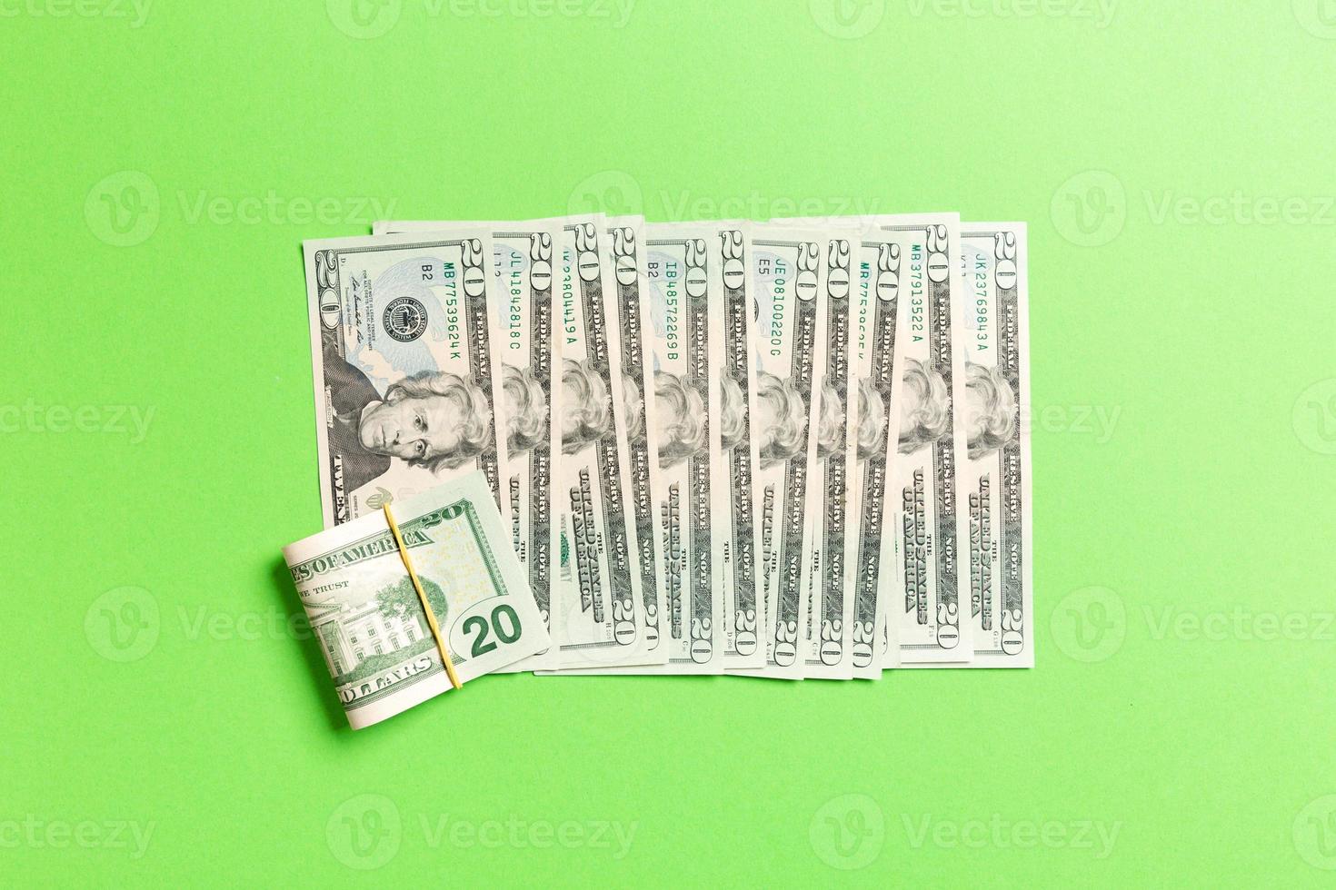 Top view of lying 20 dollar banknotes in one line on colorful background. Close up of money saving concept photo