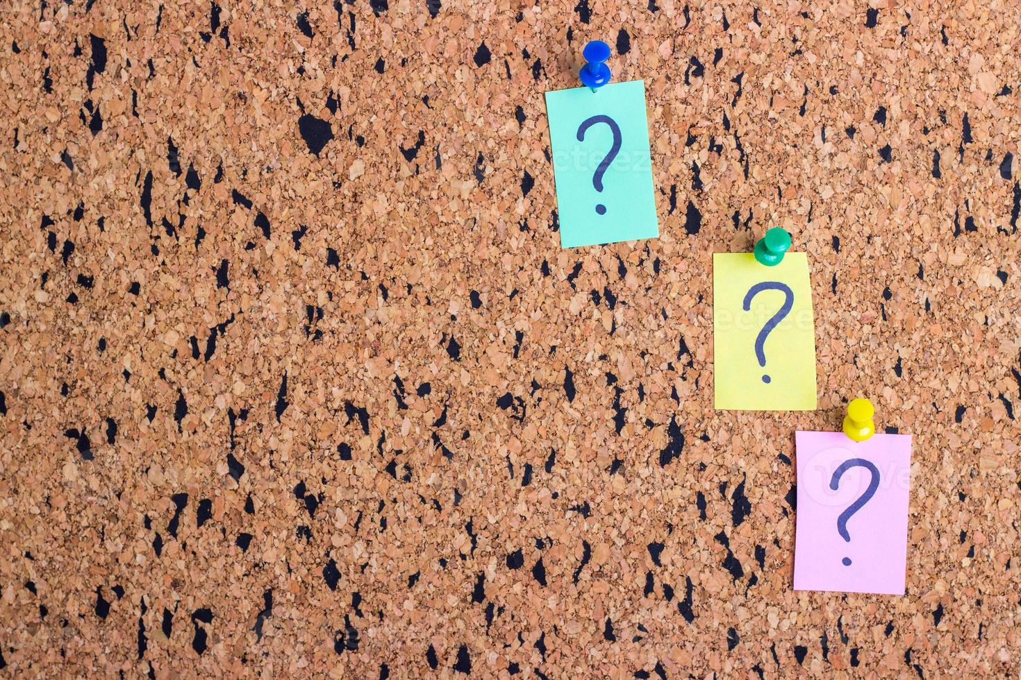 uncertainty or doubt concept, question mark on a sticky note on cork bulletin board photo