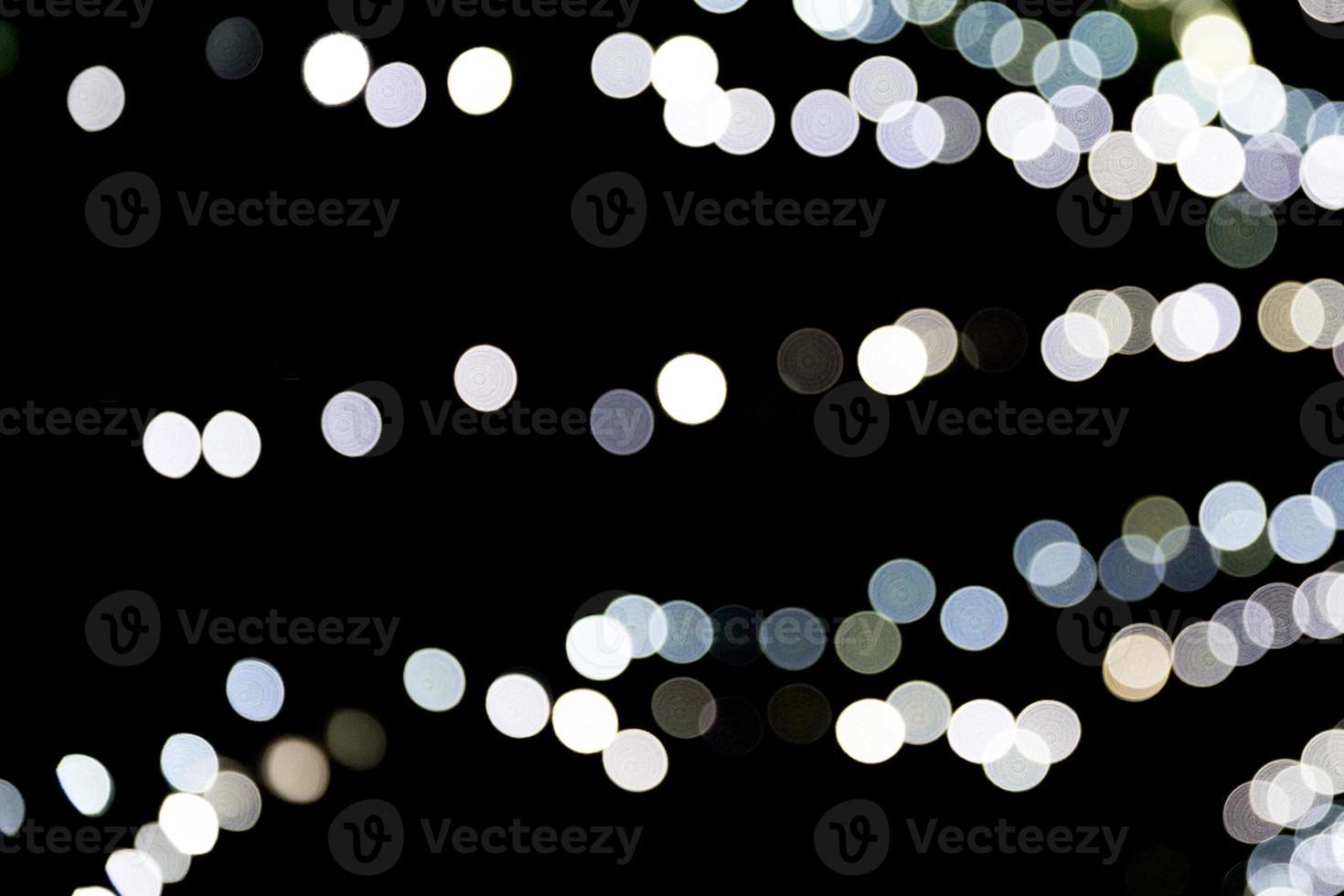 Abstract bokeh of white city lights on black background. defocused and blurred many round light photo