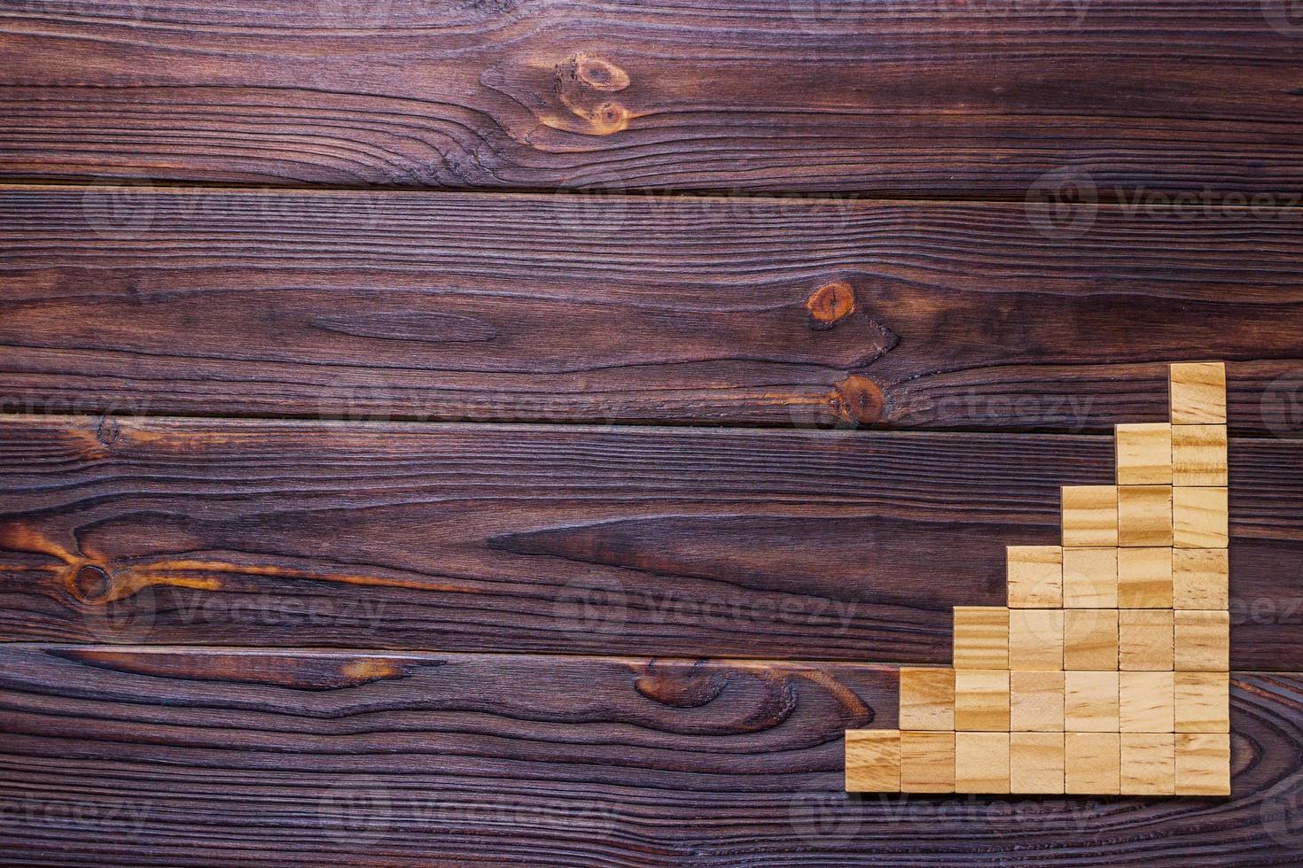 A wooden blocks cube over black wooden textured background with copy space for add word text title. Concept or conceptual Wood block stair or seven steps. Cubic photo