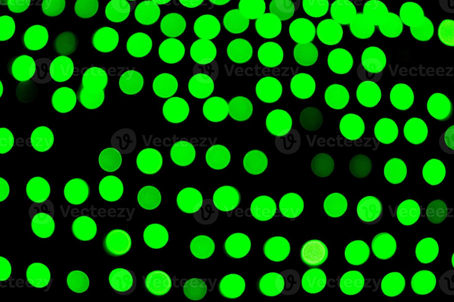 Unfocused abstract green bokeh on black background. defocused and blurred many round light photo